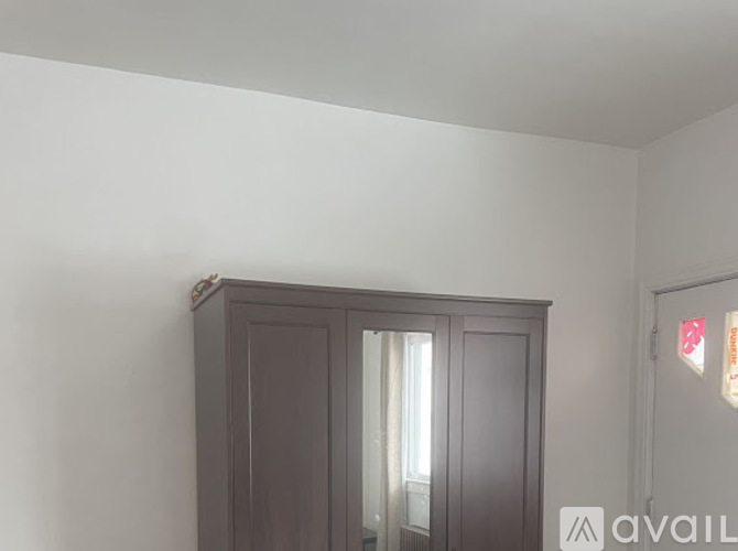 A grey cabinet with a glass door is in the corner of a room.