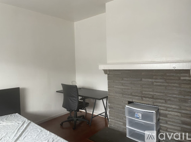 A bedroom with a bed, desk, and chair.