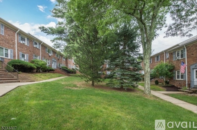 A grassy area in front of a brick apartment building.