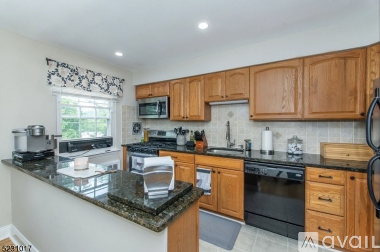 A kitchen with wooden cabinets and granite countertops.