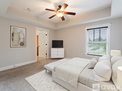 A bedroom with a bed, dresser, and television.