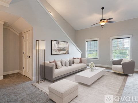 A living room with a couch, a coffee table, and a painting on the wall.
