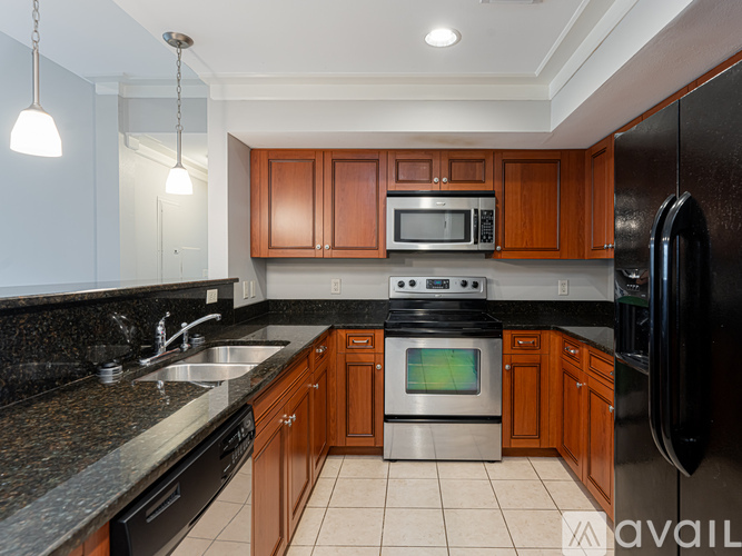 A kitchen with brown cabinets and black appliances.