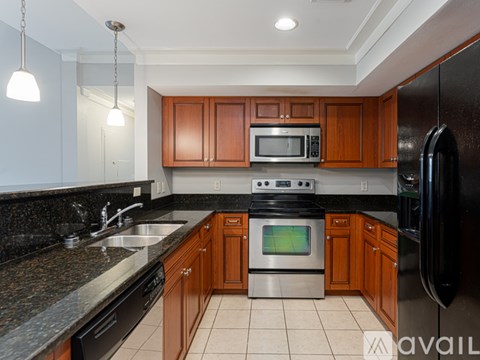 A kitchen with brown cabinets and black appliances.