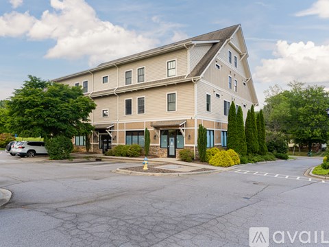 A large two-story building with a parking lot in front.