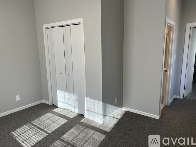 A room with a carpeted floor and a white door.