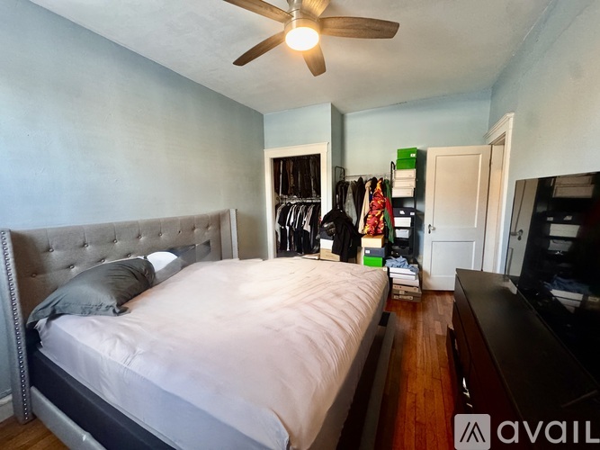 A bedroom with a large bed and a ceiling fan.