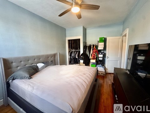 A bedroom with a large bed and a ceiling fan.