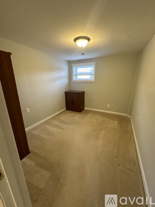 A room with a carpeted floor and a window.