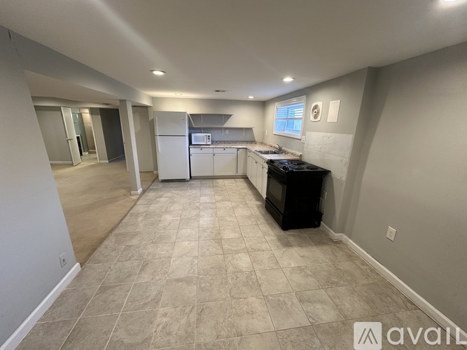 A kitchen area with a black fridge and a black microwave.