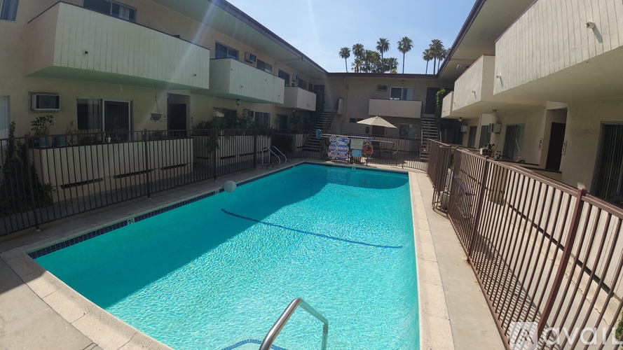 A swimming pool in a residential area surrounded by a fence.