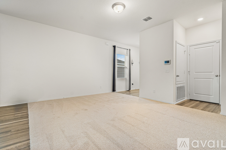 A room with a white wall and a door with a window.