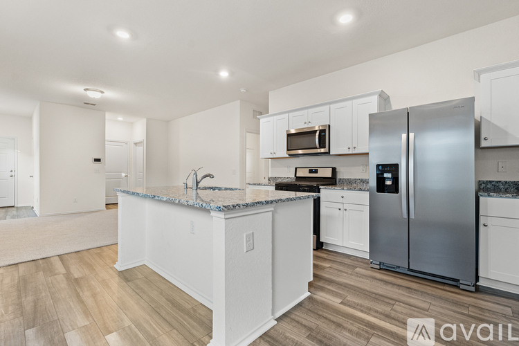 A kitchen with white cabinets and a marble countertop.