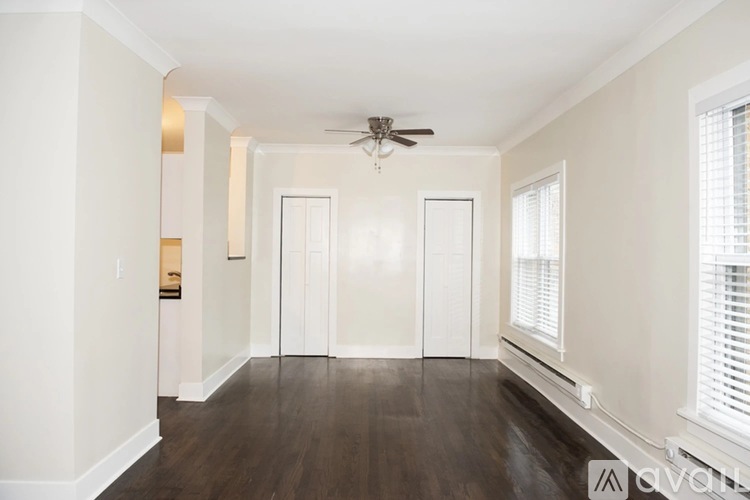 A spacious room with a ceiling fan and wooden flooring.