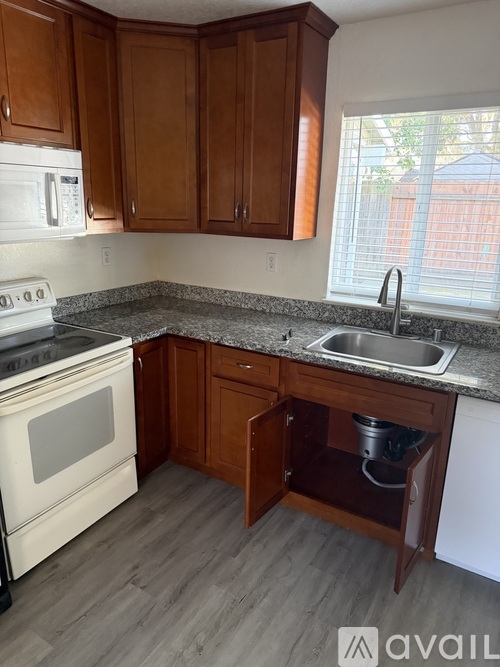 A kitchen with wooden cabinets and a white stove top oven.