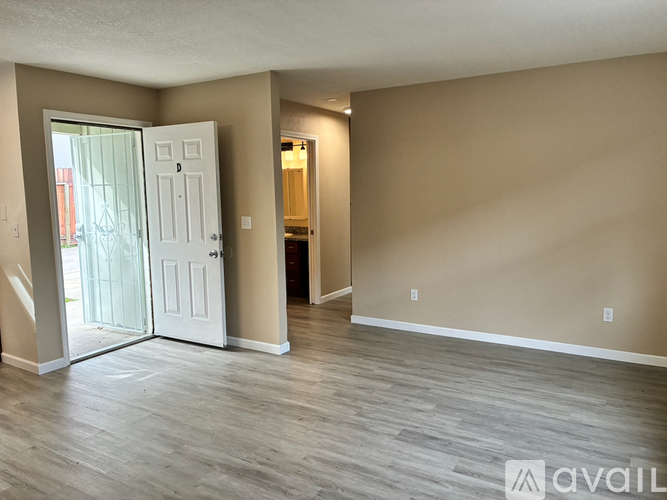A room with a white door and a wooden floor.