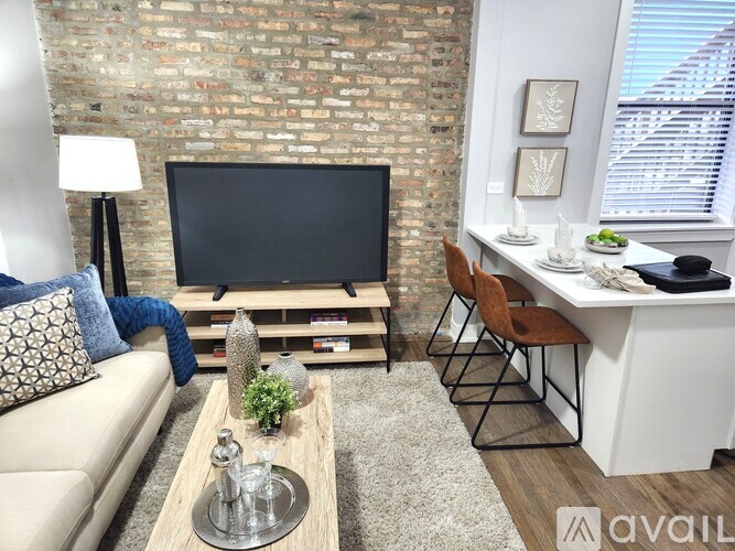 A living room with a brick wall and a flat screen TV.