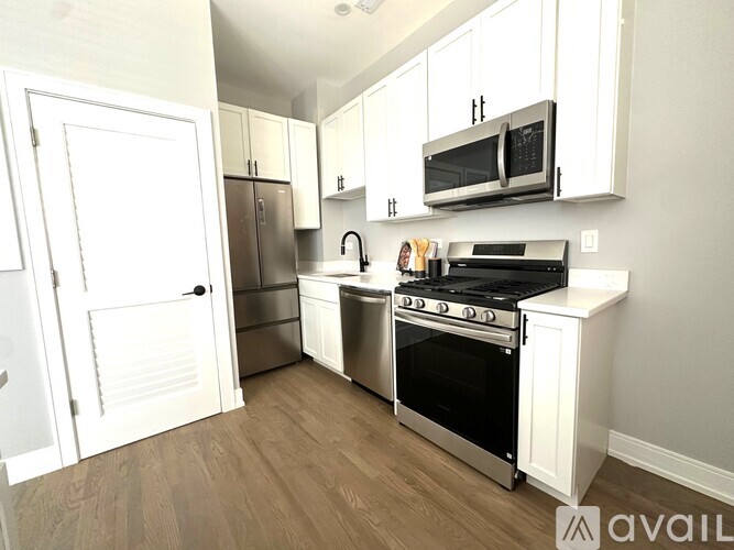 A kitchen with white cabinets and a black stove top oven.