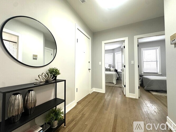 A bedroom with a round mirror on the wall and a shelf with vases.
