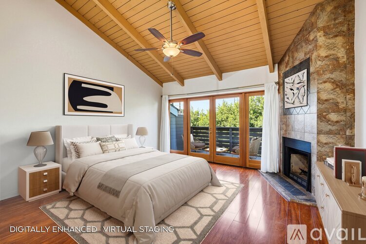 A bedroom with a large bed and a fireplace.