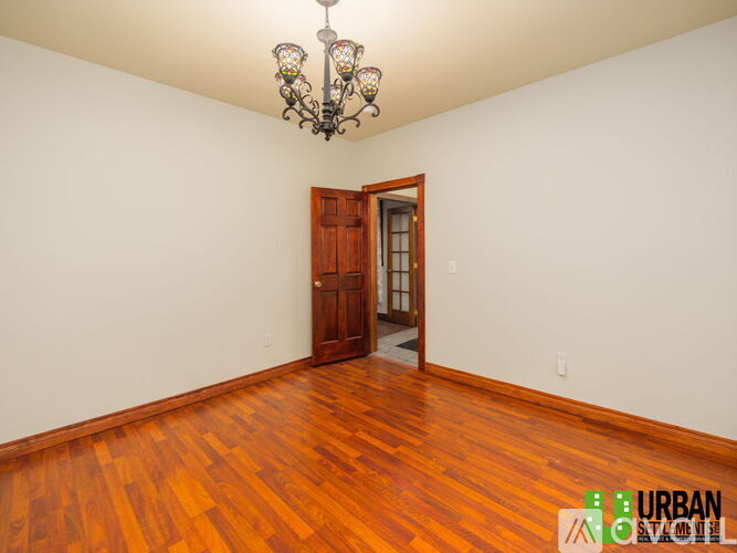 A room with a wooden floor and a chandelier.
