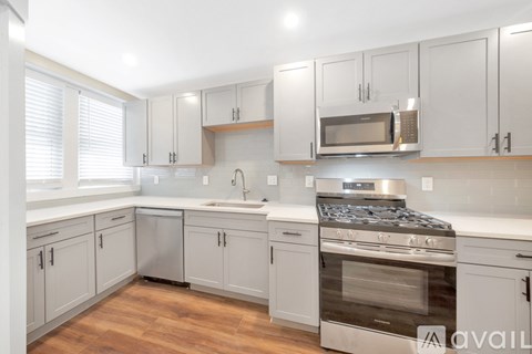 A kitchen with white cabinets and a stainless steel oven.