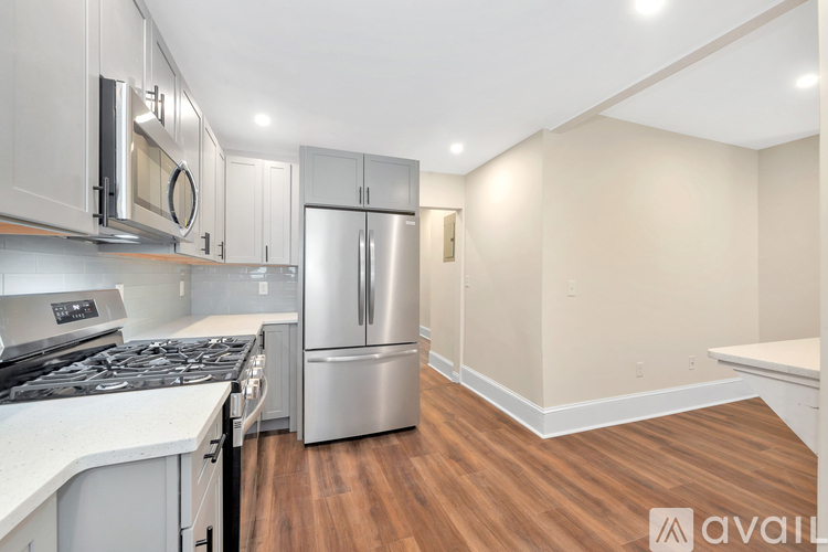A kitchen with stainless steel appliances and wooden floors.
