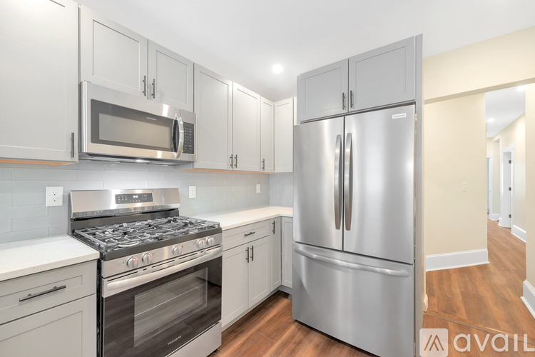 A kitchen with a stainless steel refrigerator, oven, and microwave.