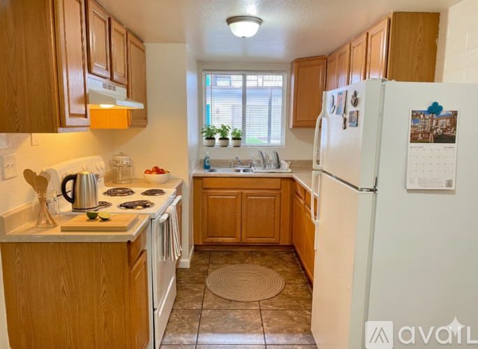 A kitchen with wooden cabinets and a white refrigerator.