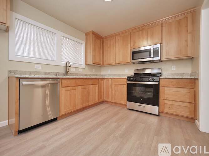 A kitchen with wooden cabinets and a stainless steel dishwasher.