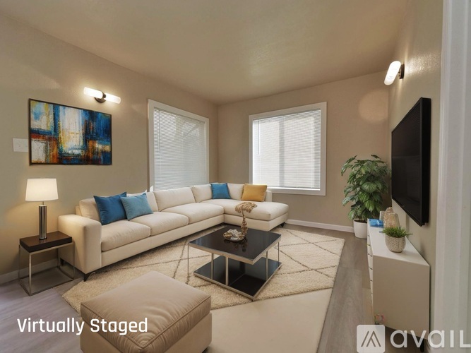 A living room with a white couch, a coffee table, and a painting on the wall.
