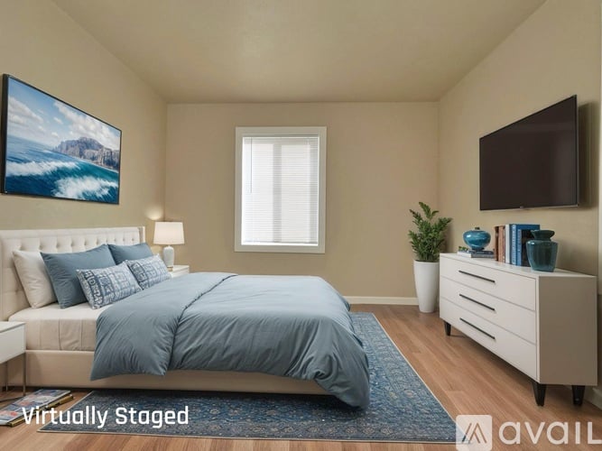A bedroom with a bed, nightstand, and a painting on the wall.