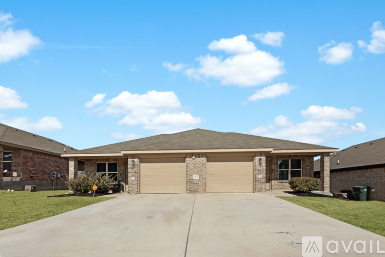 A house with a garage and a driveway in front.