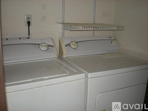 Two white washing machines in a small laundry room.