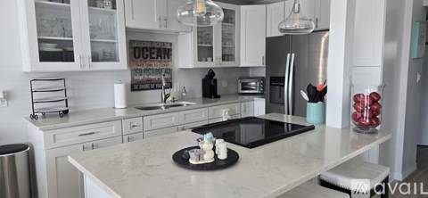 A kitchen with a white countertop and a black stove top.