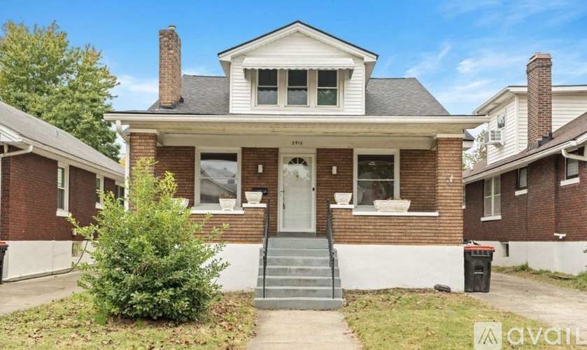 A brick house with a front porch and a white door.