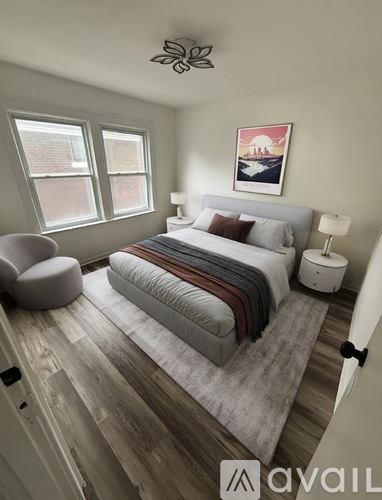 A bedroom with a bed, chair, and lamp.
