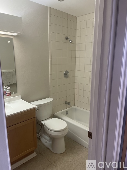 A white toilet sits next to a white sink in a small bathroom.