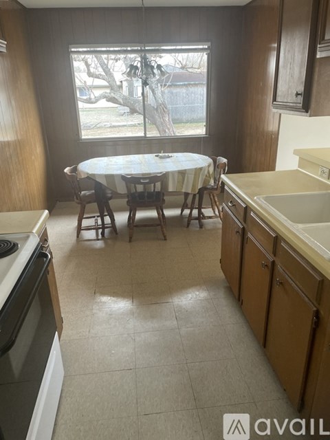 A kitchen with a table and chairs by a window.