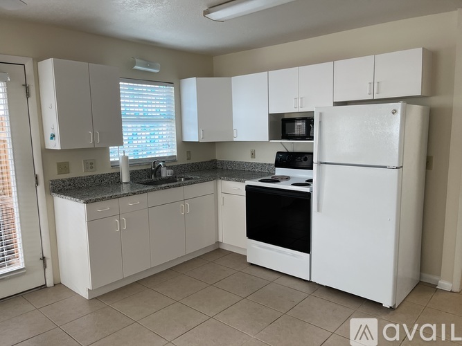 A kitchen with white cabinets and appliances.