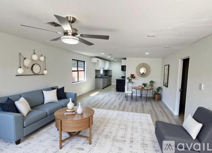 A living room with a grey couch, a wooden coffee table, and a ceiling fan.