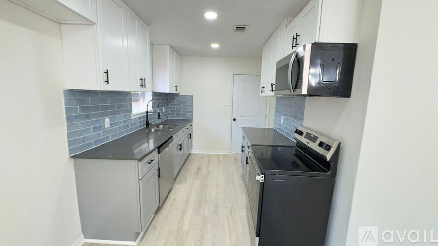 A kitchen with a black fridge and a black oven.