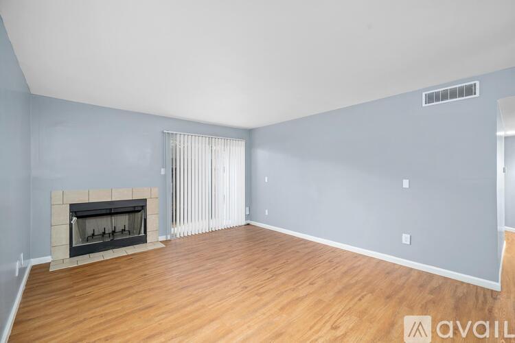 A spacious living room with a fireplace and hardwood floors.