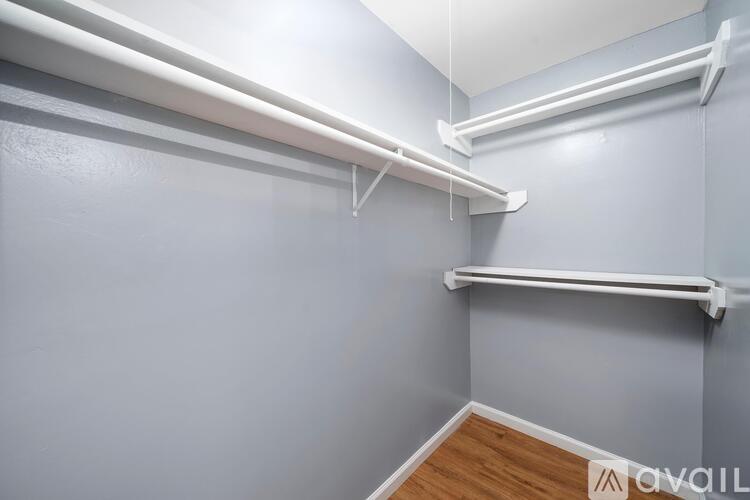 A white shelf is mounted on a grey wall.