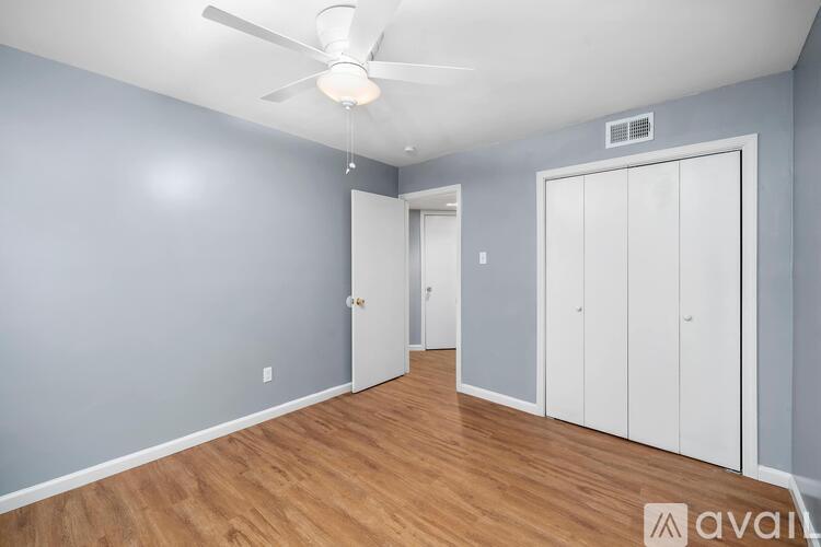 A room with a ceiling fan and two doors.