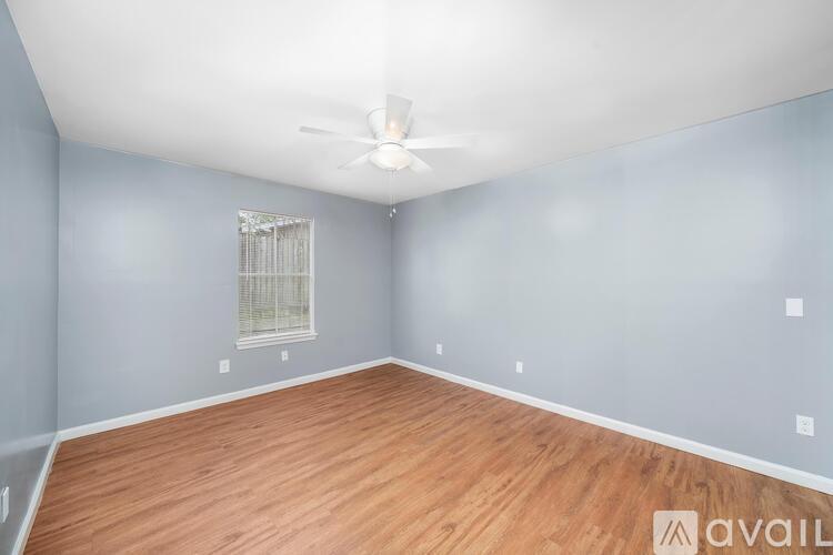 A room with wooden flooring and a ceiling fan.