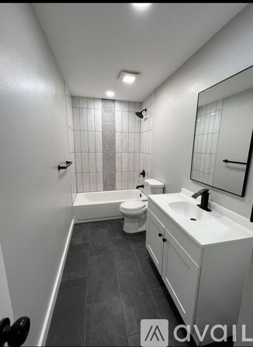 A bathroom with a toilet, sink, and bathtub.