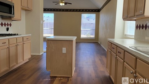 A kitchen with wooden cabinets and a tiled backsplash.