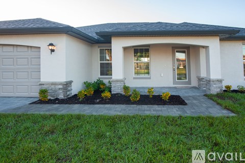 A house with a garage and a front yard with plants.
