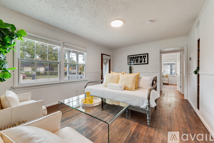 A living room with a white sofa and a glass coffee table.